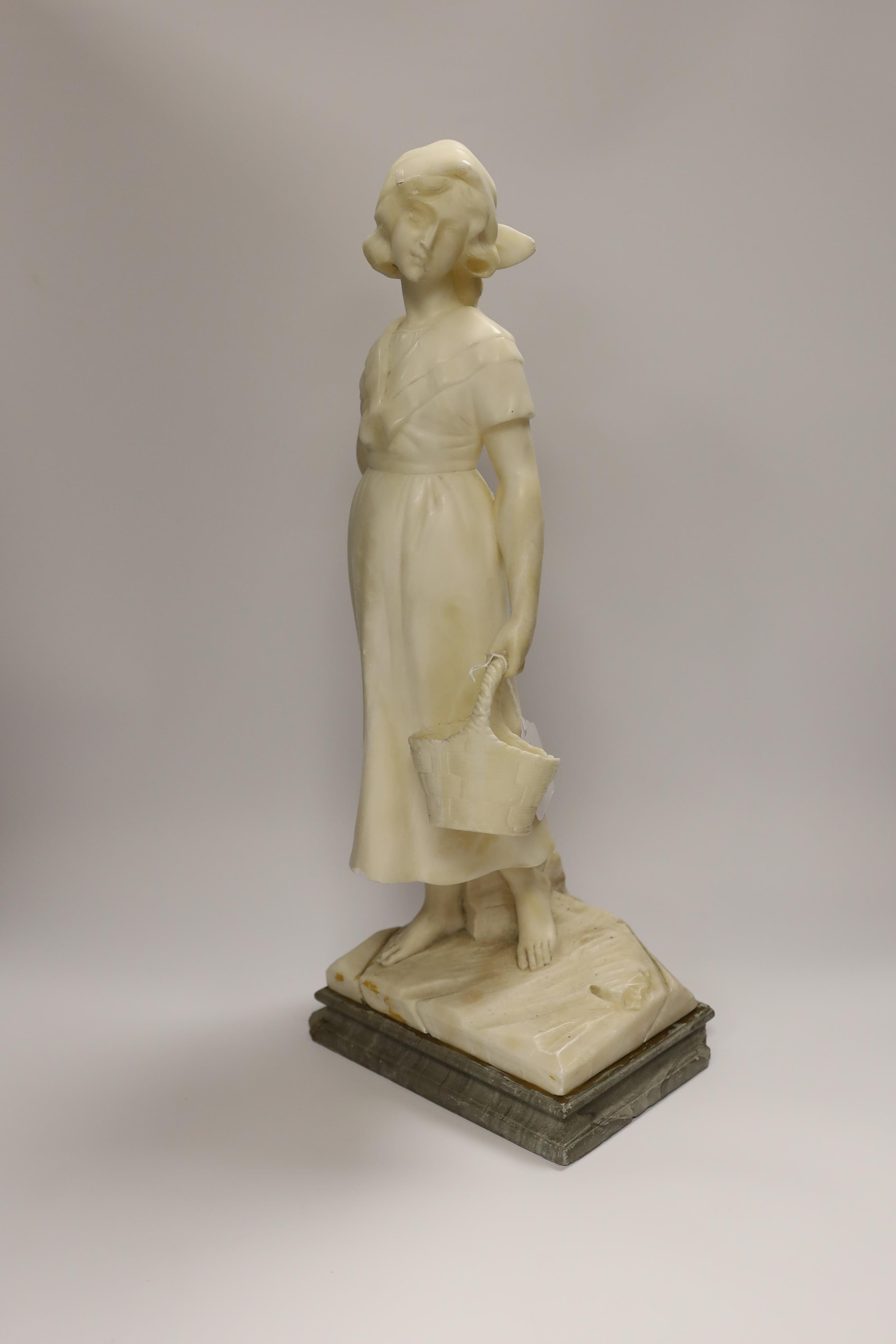 An early 20th century alabaster carved figure of a girl holding a basket, 51cm high